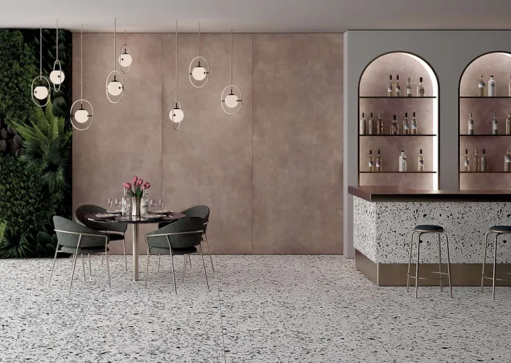 Restaurace s velkoformátovou stěnou v růžovohnědém odstínu betonu a podlahou s drobným kamínkovým vzorem (CementART)
