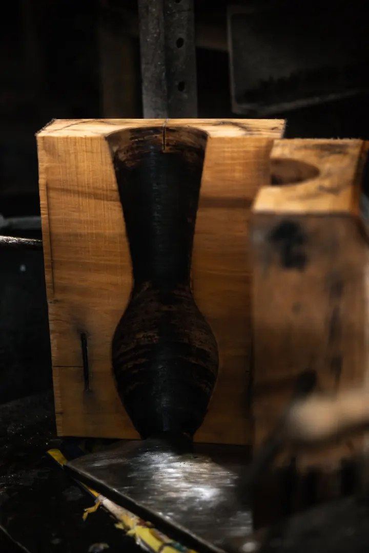 Ručně vyrobená dřevěná forma ve tvaru vázy ve sklárně
